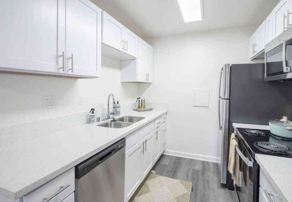 knolls on elm apartments renovated kitchen with white cabinets and stainless steel appliances