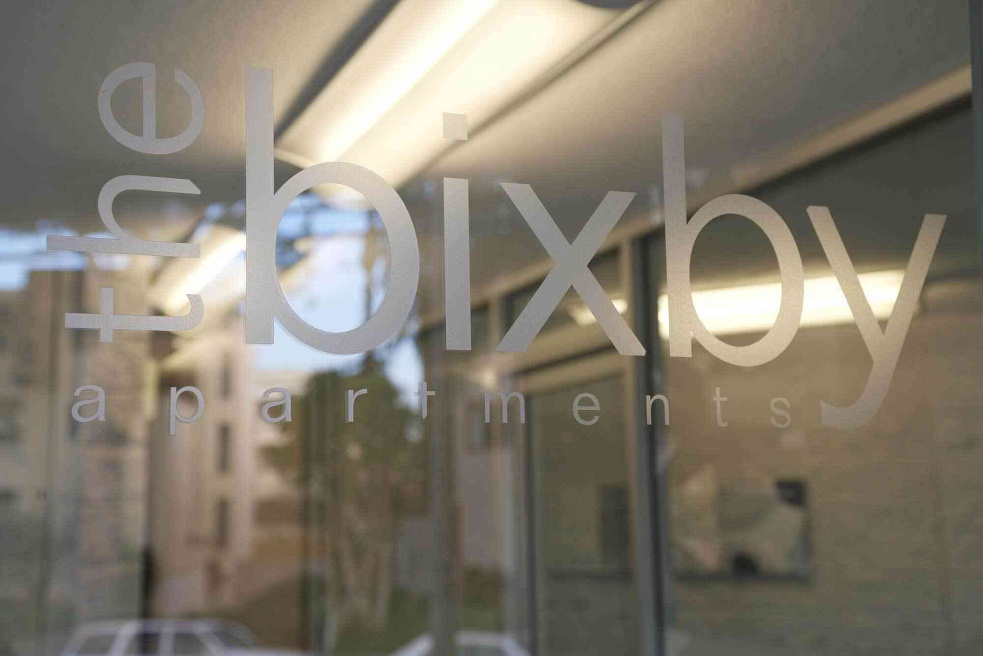 the bixby apartments community signage etched on glass entry door