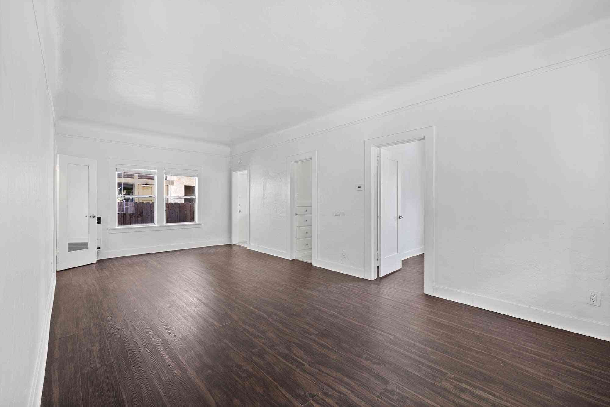 knolls on elm apartments spacious unfurnished living room with dark wood flooring