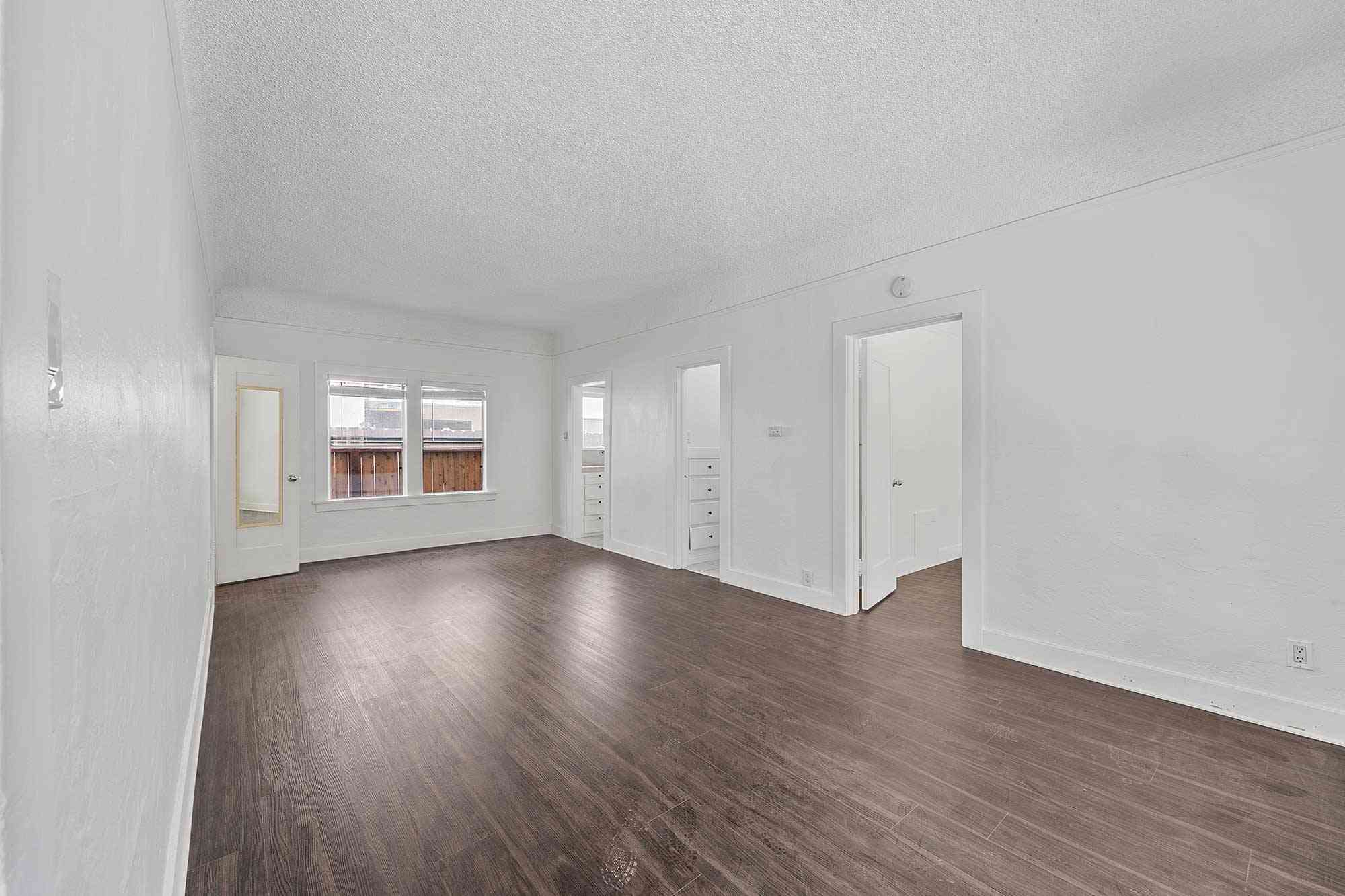 knolls on elm apartments spacious unfurnished living room with dark wood flooring