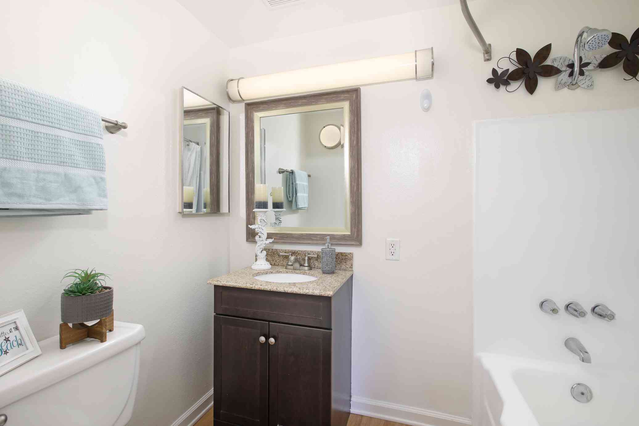 the bixby apartments modern bathroom with dark wood vanity and soaker tub