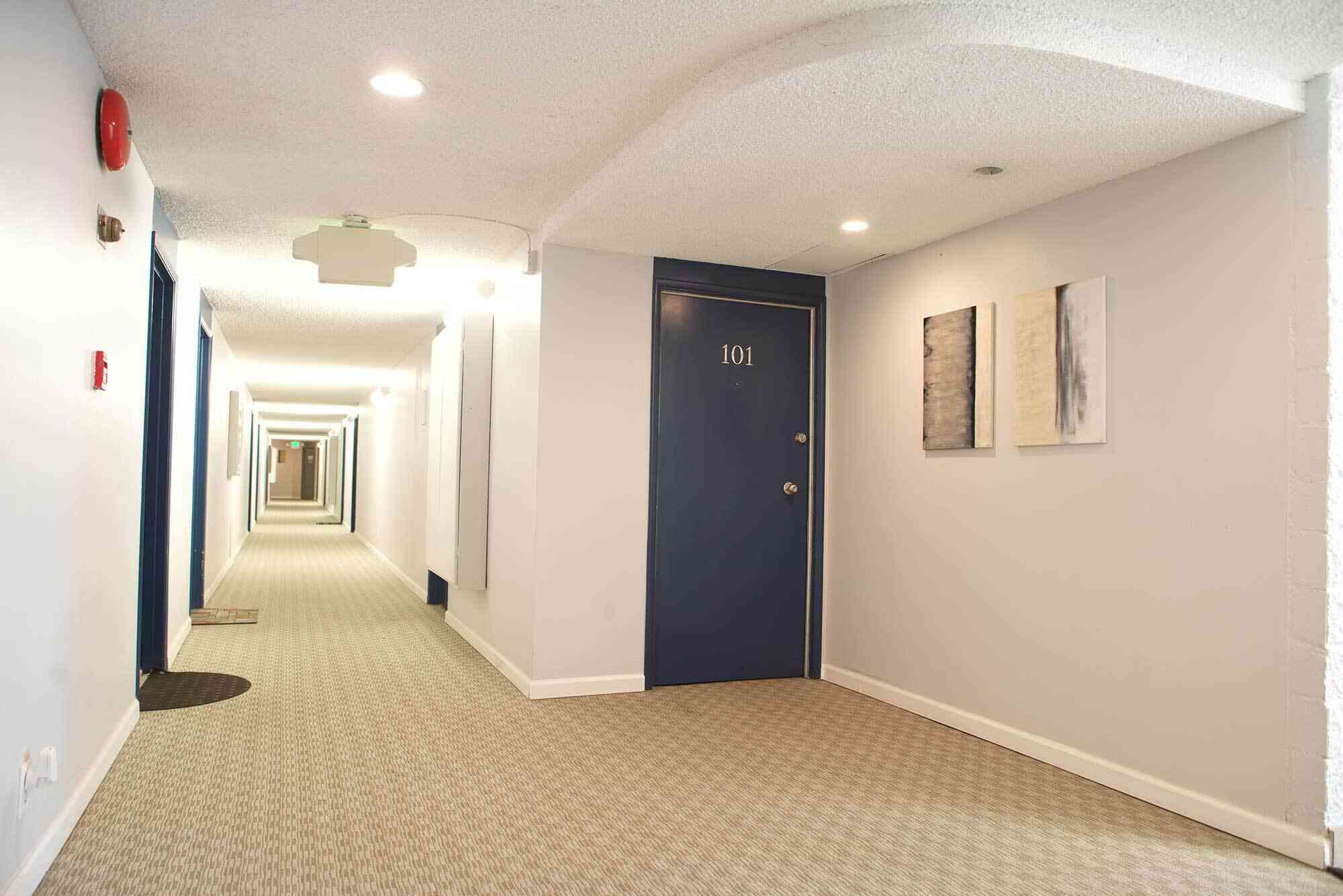 the bixby apartments carpeted interior community hallway with apartment doors
